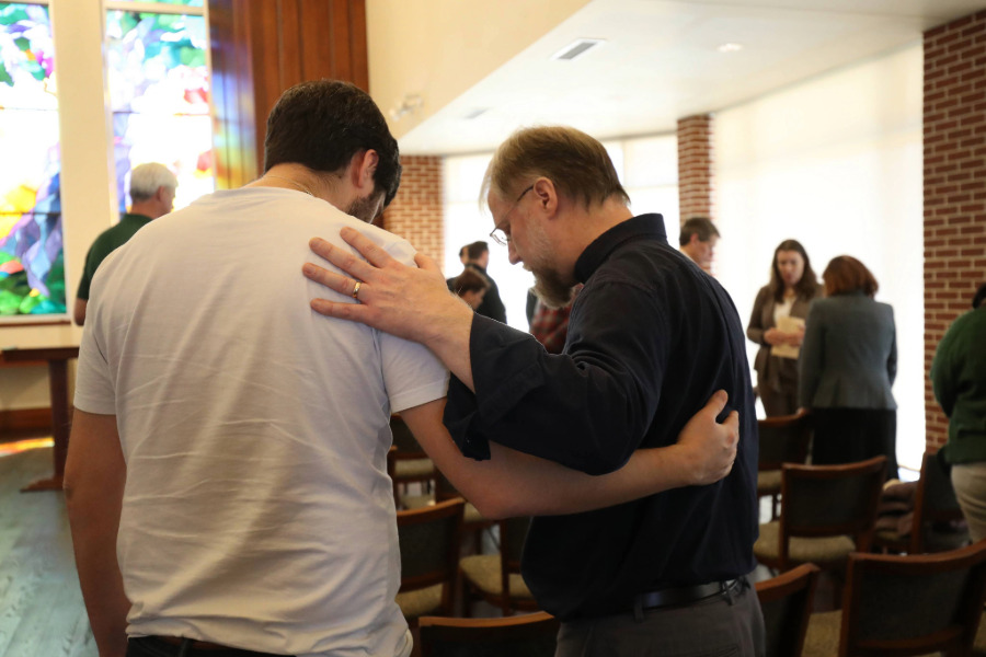 A Baylor faculty member and student praying together