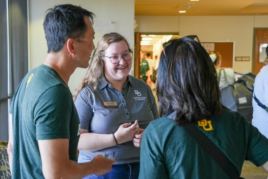 A resident chaplain speaking with two Baylor parents on move-in day