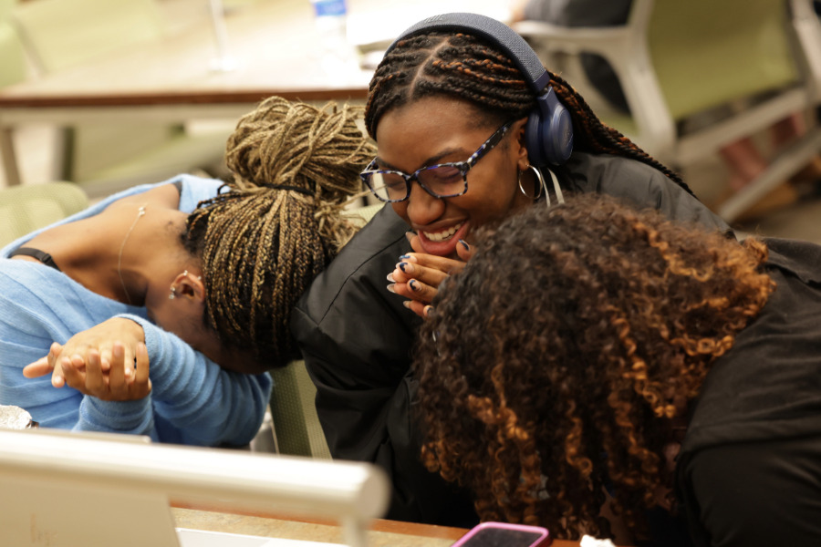Graduate students praying in front of a computer screen